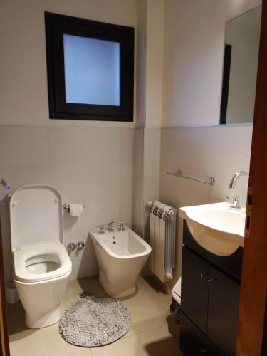 uma casa de banho com um WC, um bidé e um lavatório. em Hermoso Departamento Céntrico en San Martin de los Andes em San Martín de los Andes