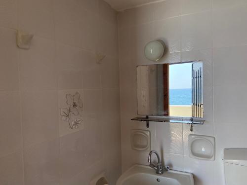 a bathroom with a sink and a toilet and a window at Coastal Charm - Sea View Room in Elíka