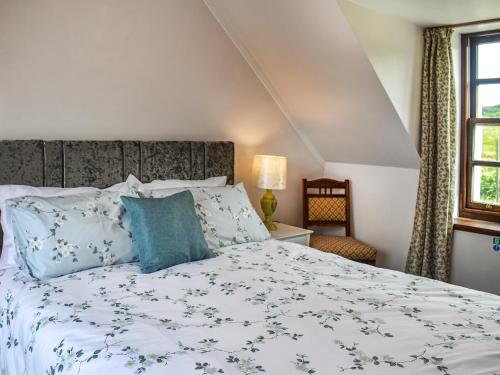 1 dormitorio con 1 cama grande con almohadas azules en Peters, en Tarskavaig