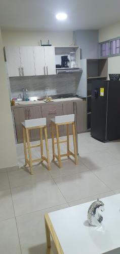 a kitchen with two chairs and a refrigerator at Acogedor ApartaStudio Zona Centro in Quibdó