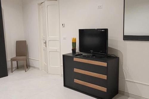 - une télévision à écran plat sur une commode dans l'établissement Lura casa vacanze, à Trepuzzi