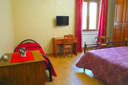 1 dormitorio con cama, mesa y escritorio en LE MIMOSE, en Spezzano Albanese