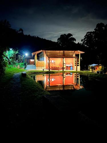 a small house is lit up at night at Chales em Salesopolis - Recanto da Barra in Salesópolis