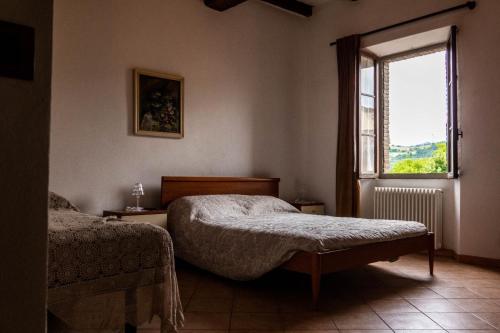 1 dormitorio con 2 camas y ventana en Affittacamere la Torre, en Marzabotto