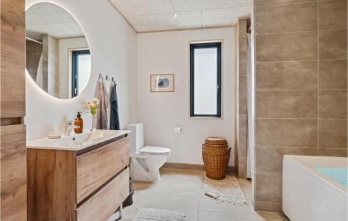 een badkamer met een wastafel, een bad en een toilet bij Gorgeous Home In Grenaa With Kitchen in Brøndstrup