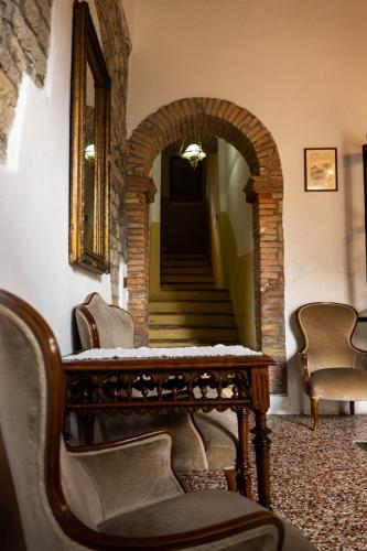 a hallway with an archway and a table and chairs at Affittacamere la Torre in Marzabotto