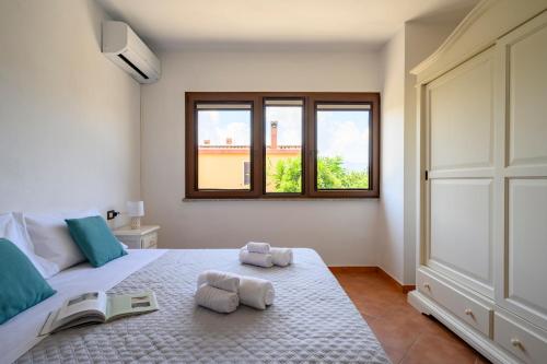 1 dormitorio con 1 cama con 2 toallas en 6 - Meraviglioso appartamento con terrazza - Sa Crai Apartments Sardinian Experience en Lotzorai