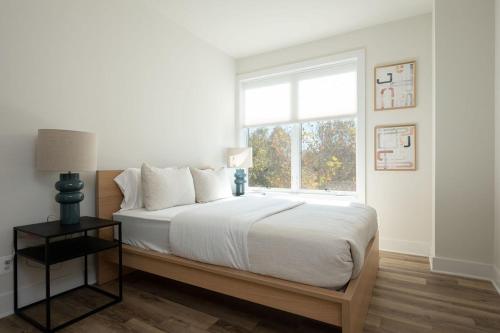 a white bedroom with a large bed with a window at Piedmont Place Suite 303 in Crozet