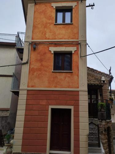 a tall building with a door and two windows at La Casa delle Rondini in Baunei