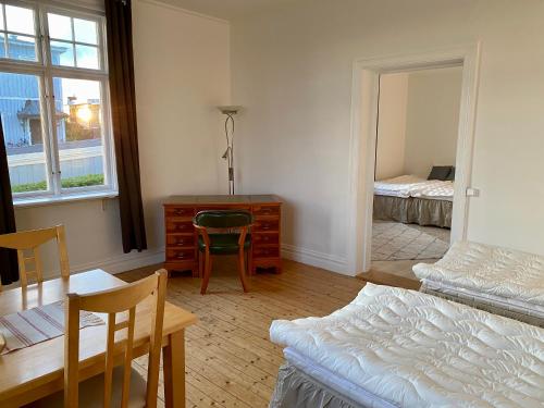 1 dormitorio con cama, escritorio y mesa en Lägenhet med havsutsikt en Strömstad