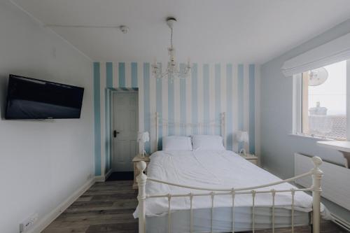 a bedroom with a white bed and a tv at Sligo Bay Lodge in Rosses Point