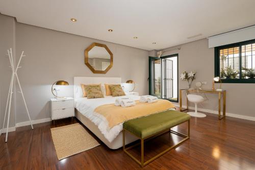 a bedroom with a large bed and a mirror at C30 Deluxe Studio with Terrace into Cathedral Square in Málaga