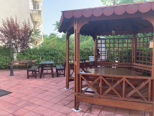 a gazebo with tables and benches on a patio at Happy smiles in Pomorie