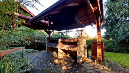 a wooden house with a roof on a stone walkway at Hotel y Cabañas Lago Ranco - Caja los Andes in Futrono