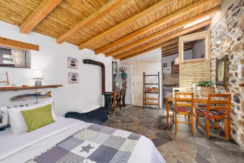 una camera da letto con un letto e un tavolo con sedie di Malsova Studio a Kotrónion