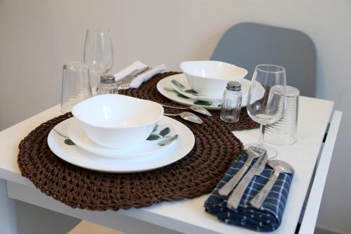 a table with plates and bowls and wine glasses at PLUTON in Saint-Quentin