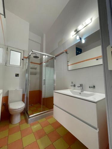 a bathroom with a toilet and a sink and a shower at PeMel Grand apartment in Aíyira