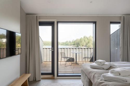 a bedroom with a bed and a balcony with a view at Pellinge Marina in Porvoo