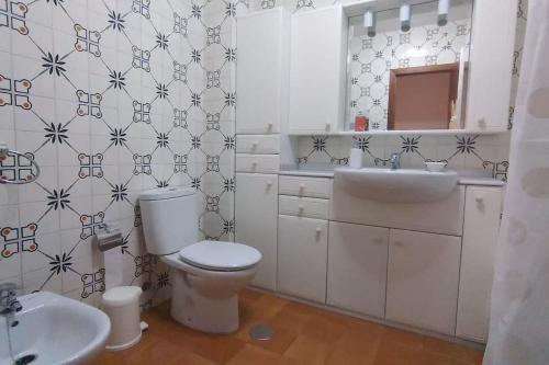 La salle de bains est pourvue de toilettes blanches et d'un lavabo. dans l'établissement Beautiful apartment with nice view to the port, à A Guarda