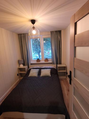 um quarto com uma cama grande num quarto em My Lake Apartamenty em Ełk