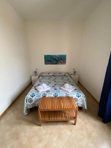 una piccola camera con letto e tavolo di A Patedda a Favignana