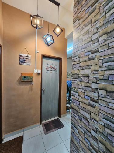 eine Lobby mit einer Steinmauer und einer Tür in der Unterkunft Lyn Melaka Homestay in Malakka