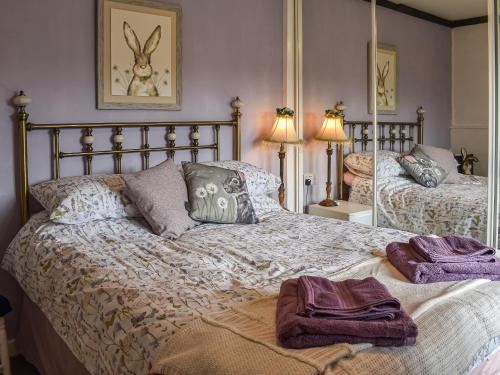 a bedroom with a bed with two towels on it at The Old Thatch in Hailsham