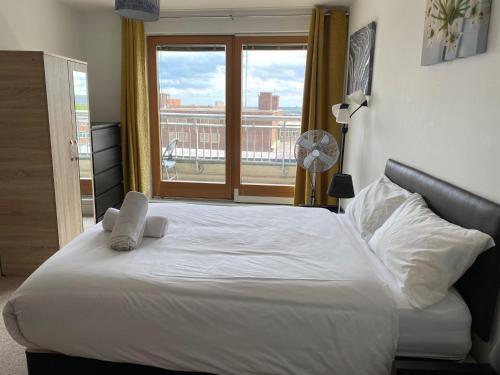 a bedroom with a large white bed with a window at Spacious 2 Bedroom Apartment at The PostBox in Birmingham