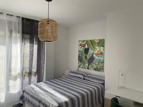 1 dormitorio con 1 cama y una pintura en la pared en Piso en la Playa en Ribeira