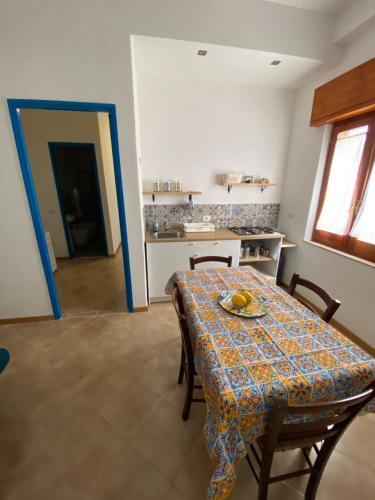 une salle à manger avec une table et une cuisine dans l'établissement A Patedda, à Favignana