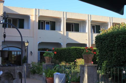 un bâtiment avec des plantes et des fleurs devant lui dans l'établissement Hotel Villa Sarah, à Capri