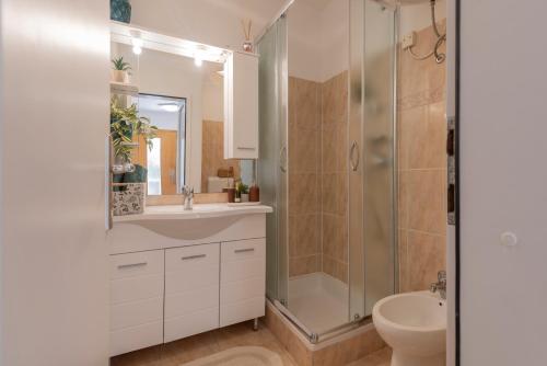 La salle de bains est pourvue d'une douche, d'un lavabo et de toilettes. dans l'établissement Casa Kiwi, à Premantura