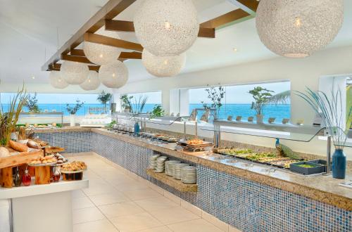プエルト・モレロスにあるDesire Riviera Maya Pearl Resort All Inclusive - Couples Onlyの海の景色を望むリゾートでのビュッフェ