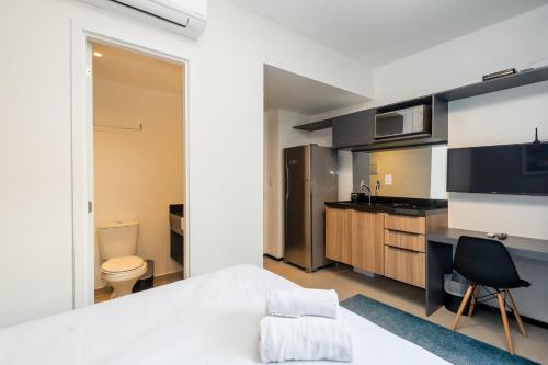 um quarto com uma cama, uma secretária e uma cozinha em 360 Suítes VN Consolação by Housi - Apartamentos mobiliados em São Paulo