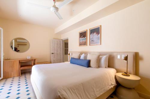 a bedroom with a large white bed and a mirror at B Haus Hotel Boutique in Cartagena de Indias