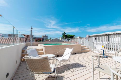 eine Terrasse mit Stühlen, einem Tisch und einem Pool in der Unterkunft B Haus Hotel Boutique in Cartagena de Indias