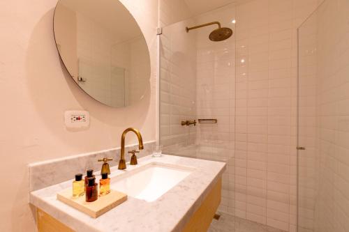 a bathroom with a sink with a mirror and a shower at B Haus Hotel Boutique in Cartagena de Indias