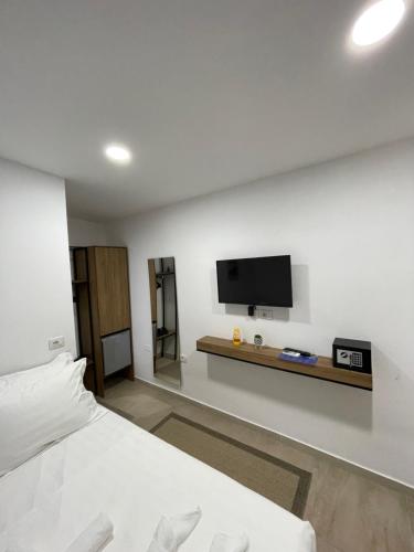 a bedroom with a bed and a tv on a wall at Hotel Kappa3 Villas in Vlorë
