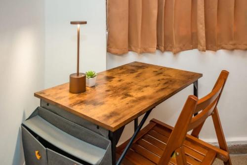 a wooden desk with a chair and a lamp on it at Hotel Caracas in Panama City