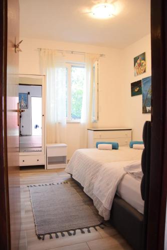 a bedroom with a bed and a large window at Apartment Bepo in Pakoštane