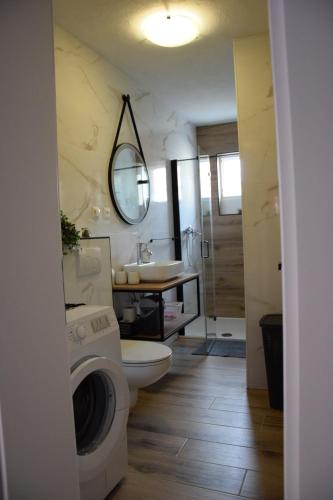 La salle de bains est pourvue de toilettes, d'un lavabo et d'un lave-linge. dans l'établissement Apartment Bepo, à Pakoštane