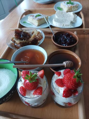 a tray of desserts with strawberries and whipped cream at Orenda in Tʼelavi