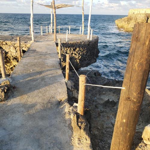 a dock with a walkway leading into the ocean at Villas El Bucanero in San Felipe de Puerto Plata