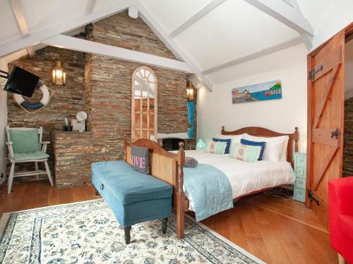 Railway Cottage في كاميلفورد: غرفة نوم بسرير وكرسي