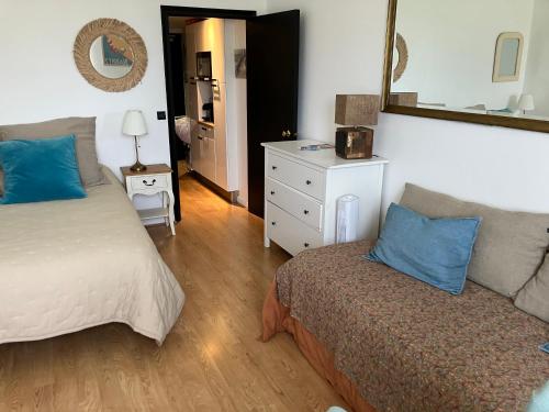 - une chambre avec un lit, un canapé et un miroir dans l'établissement Studio phare de Biarritz Résidence Régina Golf, à Biarritz