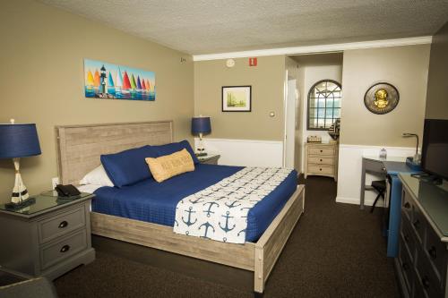um quarto com uma cama, uma secretária e uma televisão em Island View Inn em Glen Cove