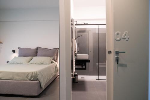 een slaapkamer met een bed en een inloopdouche bij Oktò apartments Milazzo in Milazzo