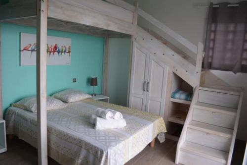 a bedroom with a bunk bed and a ladder at Villa Madjic in Sainte-Luce