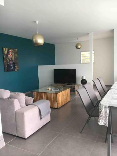 a living room with a couch and chairs and a television at Villa Madjic in Sainte-Luce