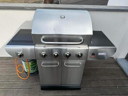 a grill sitting on a deck next to a building at Le Pré sous l'eau - NATURA in Anhée
